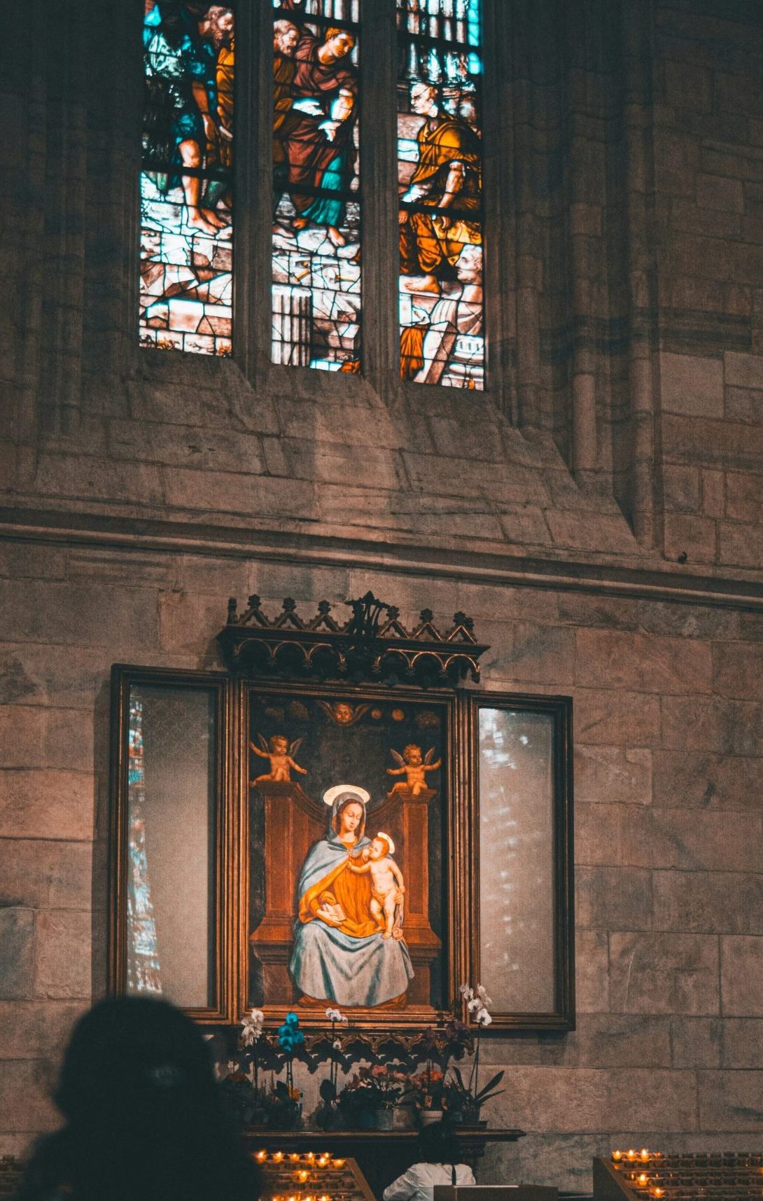 a woman sitting in front of a stained glass window